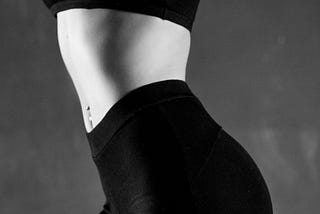 Woman’s body in leggings and a sports bra in black and white