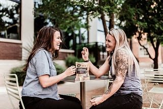 2 women laughing, eating licorice