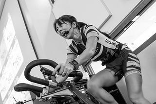 Female indoor cycling instructor on bike