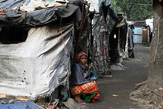 Lady sitting outside her shack