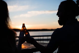 silhouette of a man and a woman celebrating on the beech for article by Larry G. Maguire