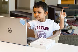 A young boy in front of a computer asking or help showing the power of asking questions