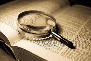 A magnifying glass over an open dictionary