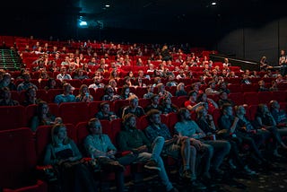 Movie theater full of people watching a movie