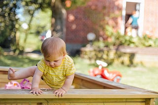 Baby Climbing out of Sandbox