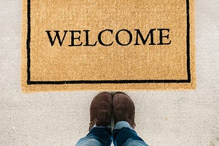 A welcome mat with two feet planted in front.