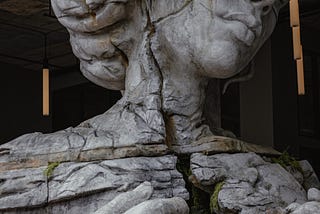 A cracked and empty self depicted as a stone statue.