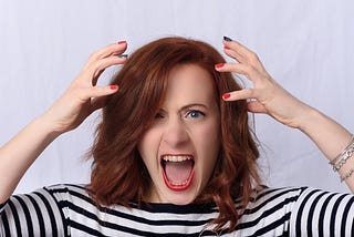 Woman looking very frustrated and ready to tear out her hair.