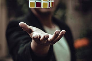 A Rubik’s cube floating above a man’s open palm