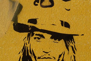 Art of Johnny Depp, done in black stencil against a yellow background.