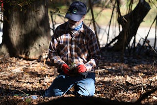 Gary Crider prepares to plant a blue mistflower during a native species planting in Athens, Georgia on Saturday, November 11. Blue mistflower attracts pollinator insects like butterflies which are essential for a healthy environment. (Photo by Alex Arango).