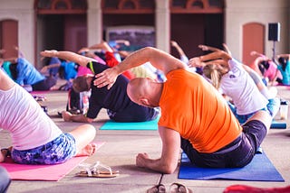 An exercise class stretching their arms.