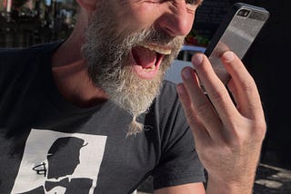 Angry white man yelling into phone.