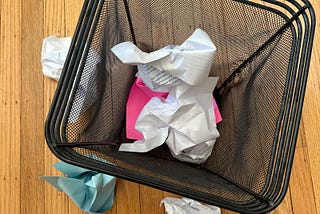 A photo of my waste basket with crumpled up papers