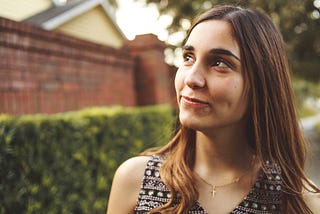 Woman with half-smile looking at angle outdoors