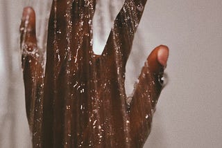 Hand touching water in shower.