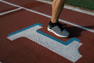 Person’s foot lifted to run on a track above the number 1