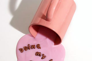 a mug spilling a pink liquid with cereal letters showing the text „doing my best”