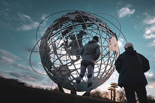 Person standing in front of a large world globe.
