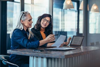 A manager and her team member discussing a report together.