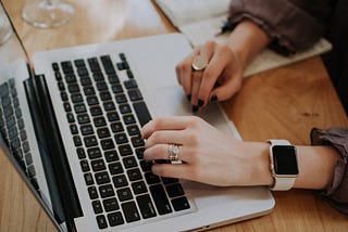 woman’s hands typing on a laptop keyboard