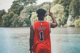 A black male wearing a Derrick Rose Chicago Bulls jersey