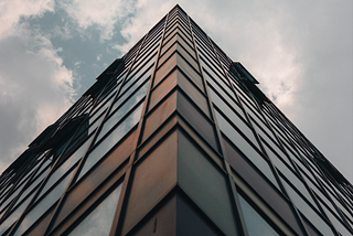 Low-angle photograph of a tall building under clouds