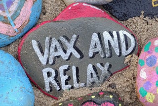 A poster with some colorful rocks painted, with the words ‘Vax and relax’ in the middle.