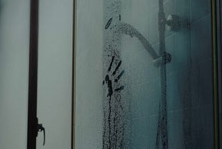 Shower with hand print on glass.