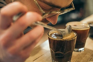 A man smelling a cup of coffee