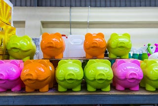 a row of brightly colored piggy banks