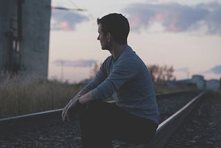a man looking to the cloudy sky in the horizon and thinking