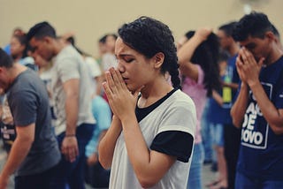 Woman and crowd in prayer