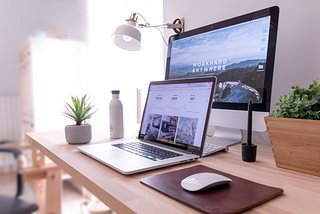 one laptop and a monitor placed on a desk