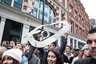 Protestors march carrying the symbols of the QAnon conspiracy group.