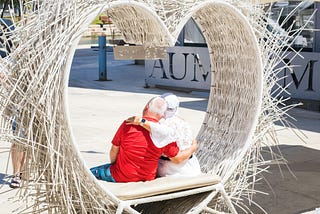 Older couple sitting inside a heart shape that has spikes all over it.