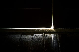 A dark door with a bright white light behind it