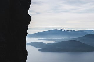 man looking at beautiful landscape from edge of cliff