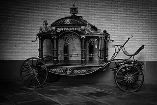 1920s style horse-drawn hearse, black and white