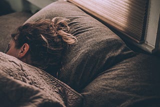 Woman sleeping with morning sunlight coming through the window.