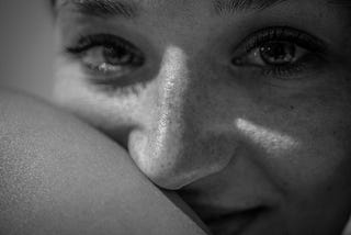 Black and white image of women half smiling at camera.