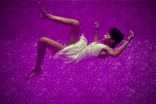 Sleeping woman falling through purple dreamlike world