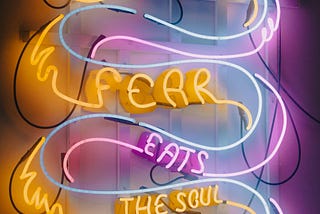 Neon lights make a snake, in the snake is written; “fear eats the soul”