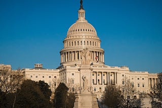 Blue background with the west front of the US Capitol building