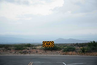 A road comes to an end with a two-way sign, with the options to turn either right or left