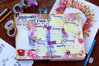 A two-page spread in a journal for September 2020. It contains a To Do List and sections for each day of the week. Surrounding these boxes are stickers, leaves, and other colorful items.