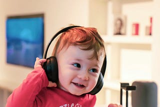 Small re-headed child listening on headphones