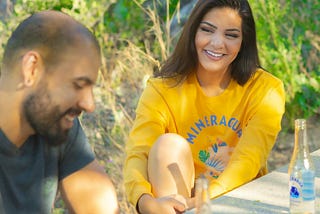 man and woman having a beer at a park