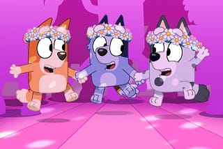 Cartoon image of orange dog, blue dog, and gray dog toddlers dancing in flower crowns, from the show Bluey.