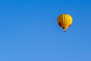 A yellow balloon in a blue sky